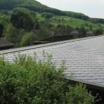 SunStyle solar tiles creating a solar roof on this industrial building that generates power for an indoor plant nursery