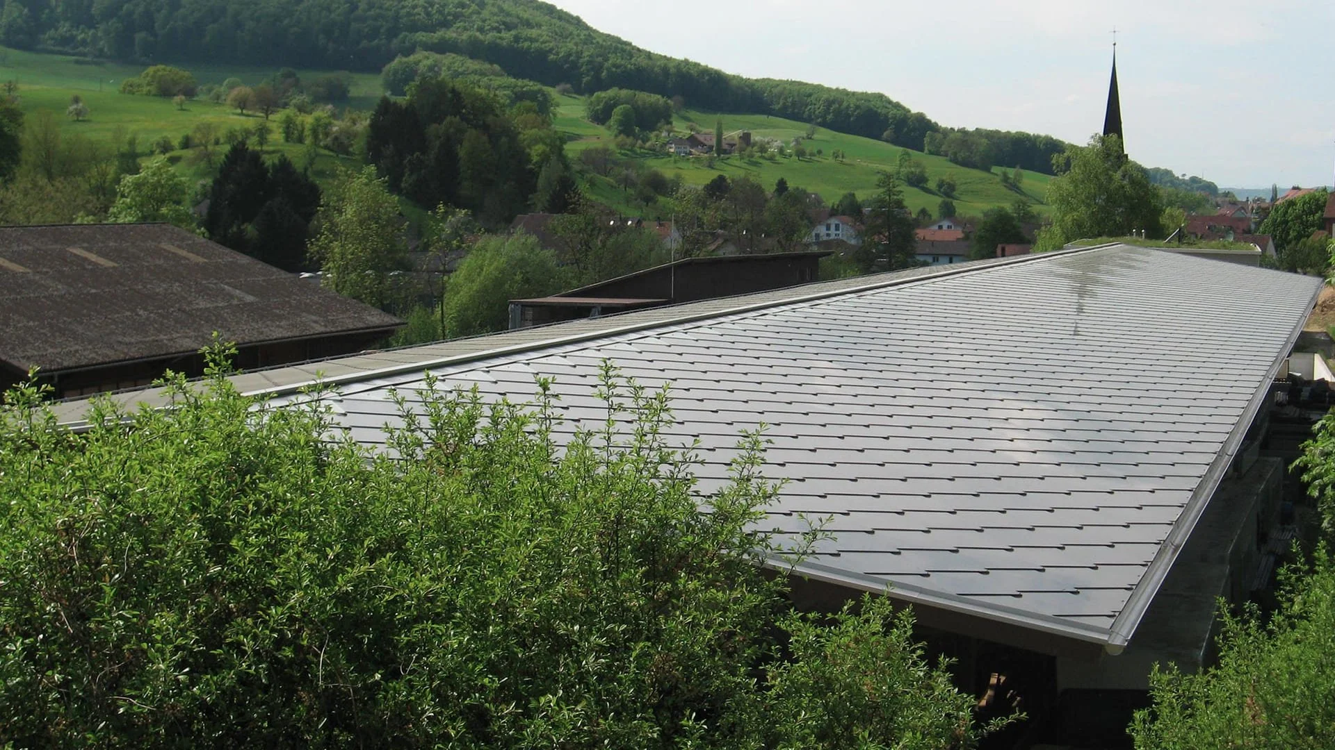 SunStyle solar tiles creating a solar roof on this industrial building that generates power for an indoor plant nursery