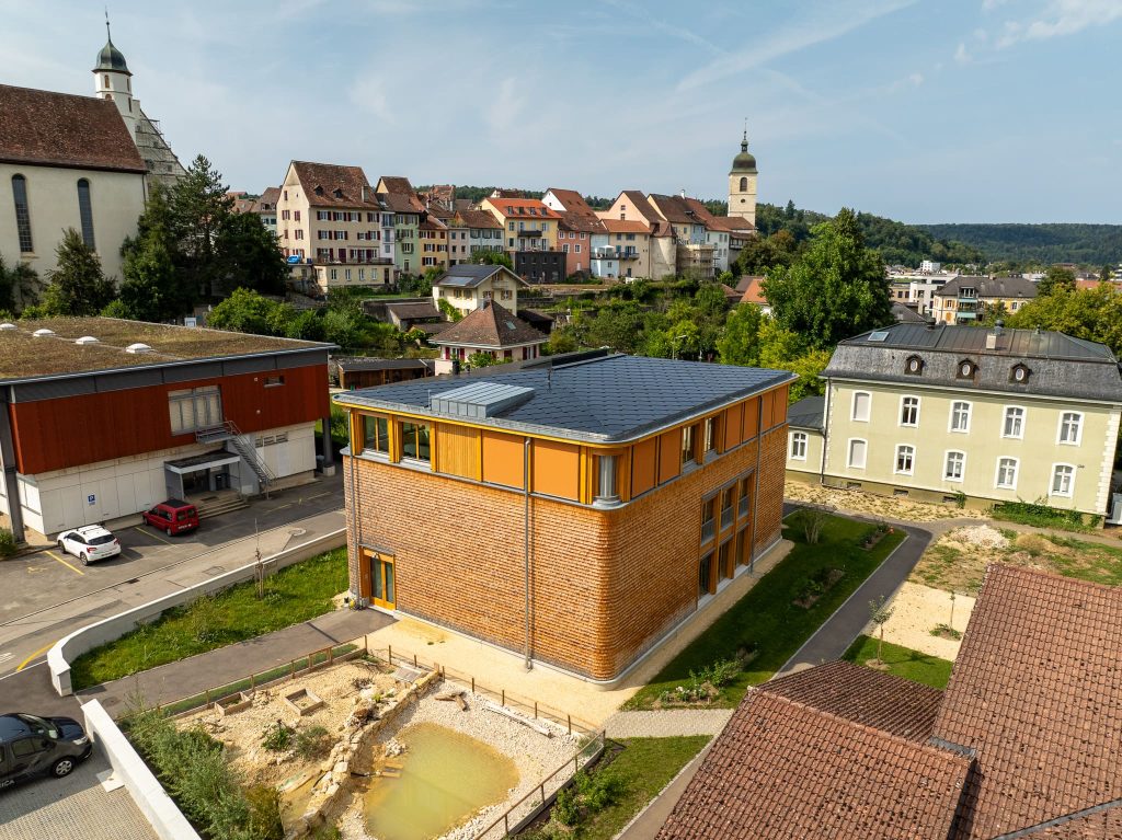 CH-2024 | 745 black | Jurassica Porrentruy_09_web Jurassica, Porrentruy-Solardach-BIPV-SunStyle-geringe Neigung-Flachdach-mit Altstadt